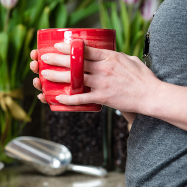 red coffee cup held in hands